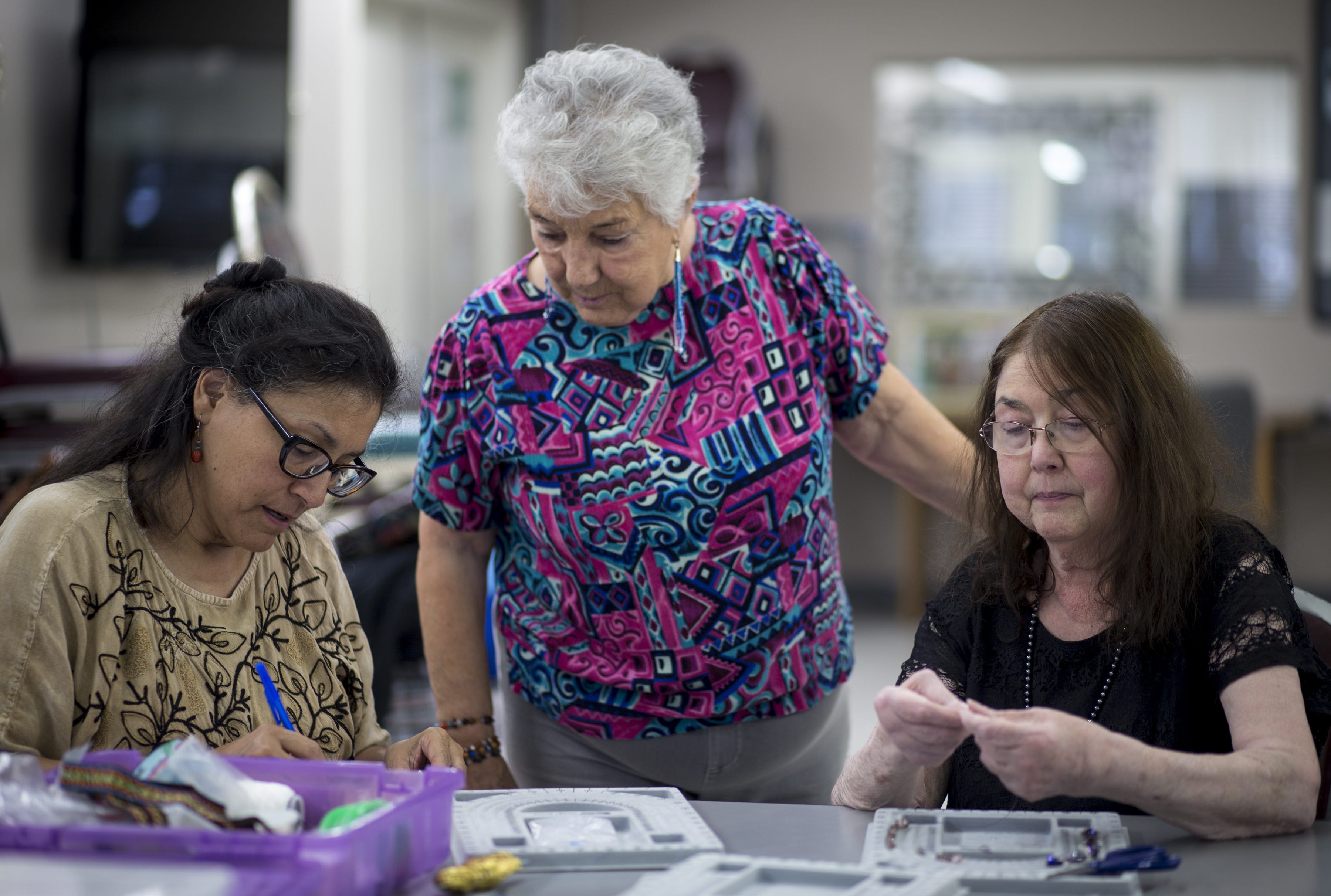 Barbara Cory (right) and Cynthia Fodness make jewelry, Dec. 12, 2018 at Phoenix Senior Opportunities, 1220 S. Seventh Ave. in Phoenix. Looking on is their instructor, Fina Gaffney (center). Cory copes with asthma that can flare up when smog worsens in Phoenix’s winter months.